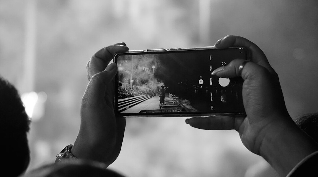 person filming with smartphone