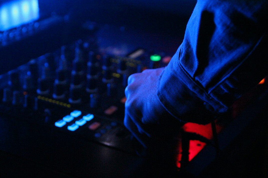 Sound engineer adjusting an audio mixing console