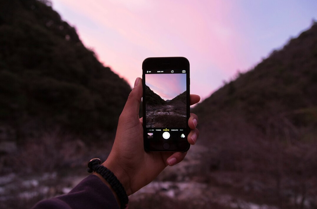 person filming with smartphone